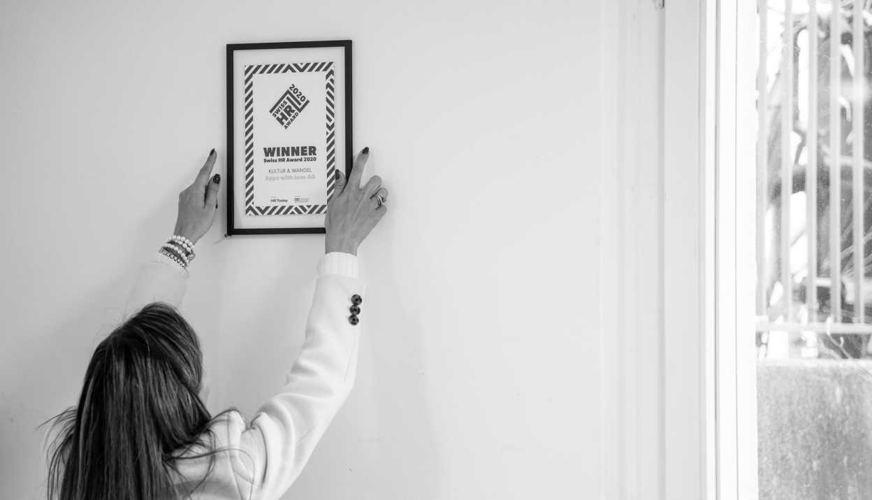 Sonia hängt das Apps with love Swiss HR Award 2020 Gewinnerzertifikat an die Wand