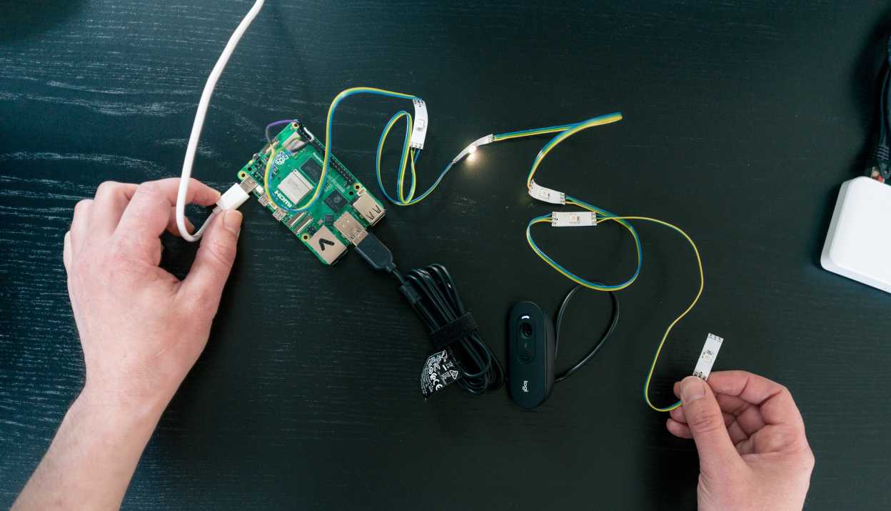 Two hands working with cables and electronics to install components and sensors