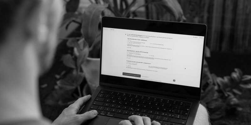 Eine Person von hinten über die Schulter fotografiert, die an einem Laptop arbeitet und die Co-Pilot-Benutzeroberfläche geöffnet hat.
