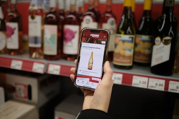 Smartphone avec scanner de vin ouvert devant un casier à vin