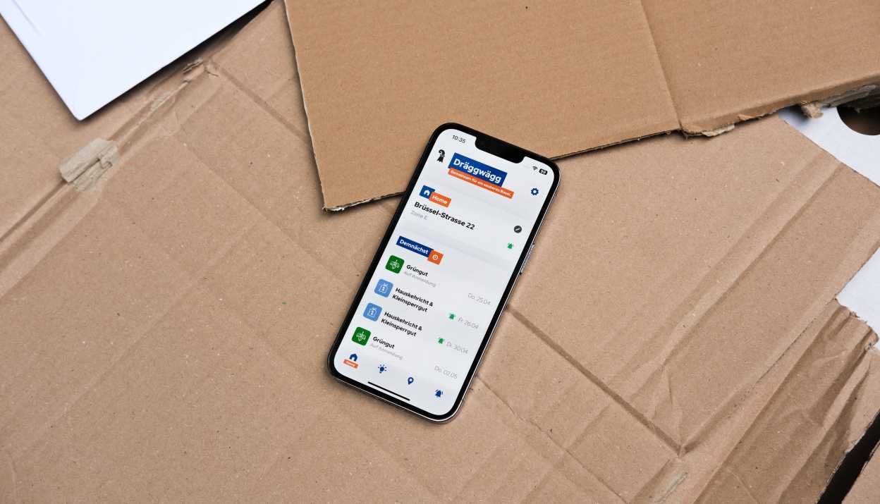 Application Dräggwägg ouverte sur un iPhone posé sur un carton.
