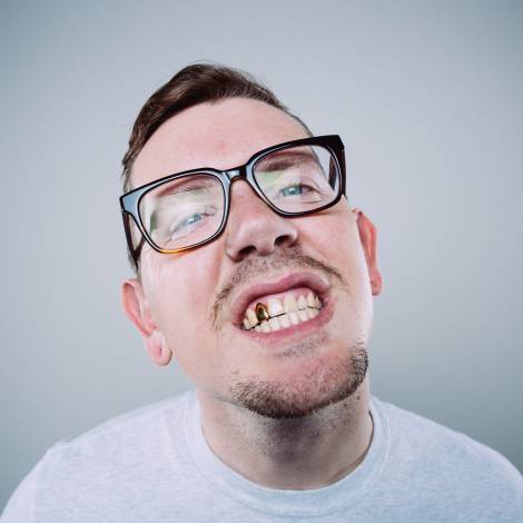 Mann mit Brille und Goldzahn