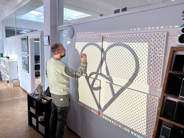 Stefan Spieler zeichnet das Apps with love Logo auf die neue Device Wall