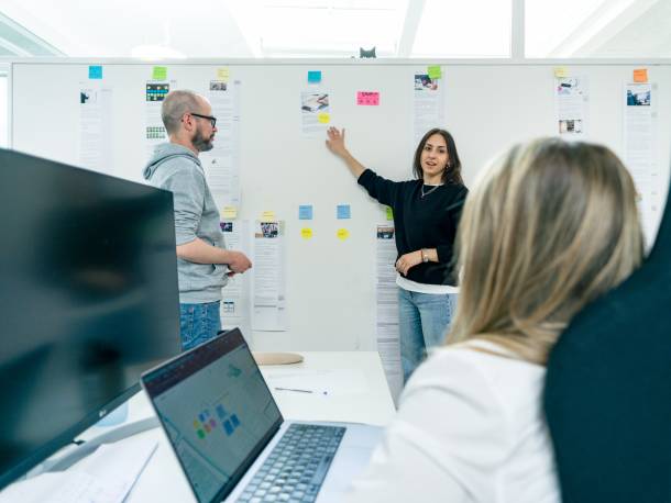 Valentin und Maya erklären Texte, die ausgedruckt an einer Wand aufgehängt sind